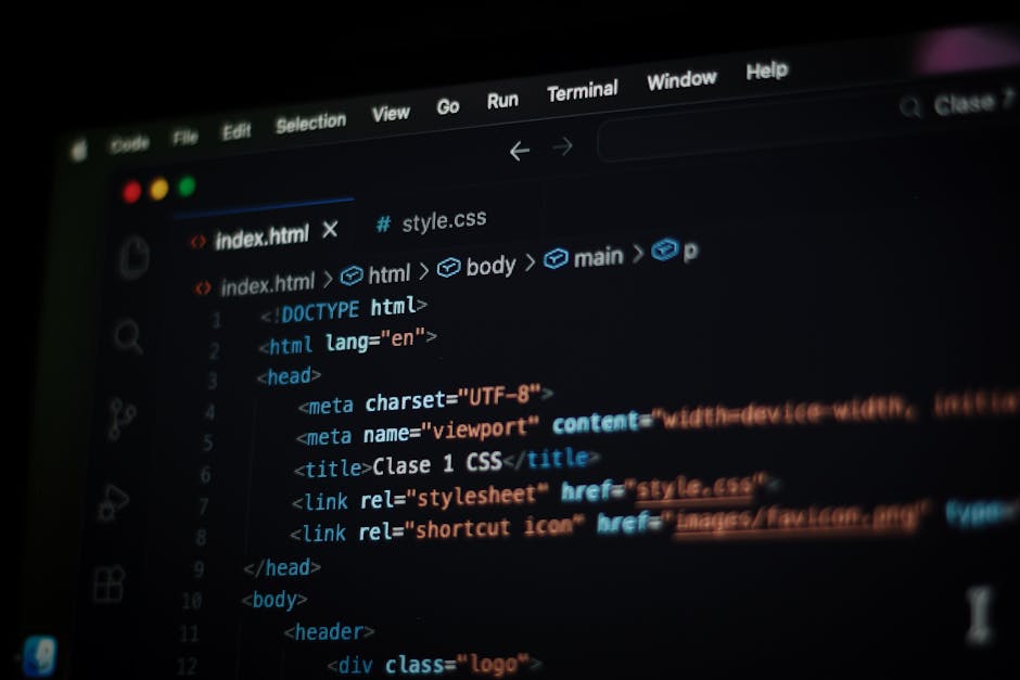 A person using a laptop to work on coding or programming, with the screen displaying a code editor filled with lines of code, folders, and options. The individual's hands are positioned over the keybo